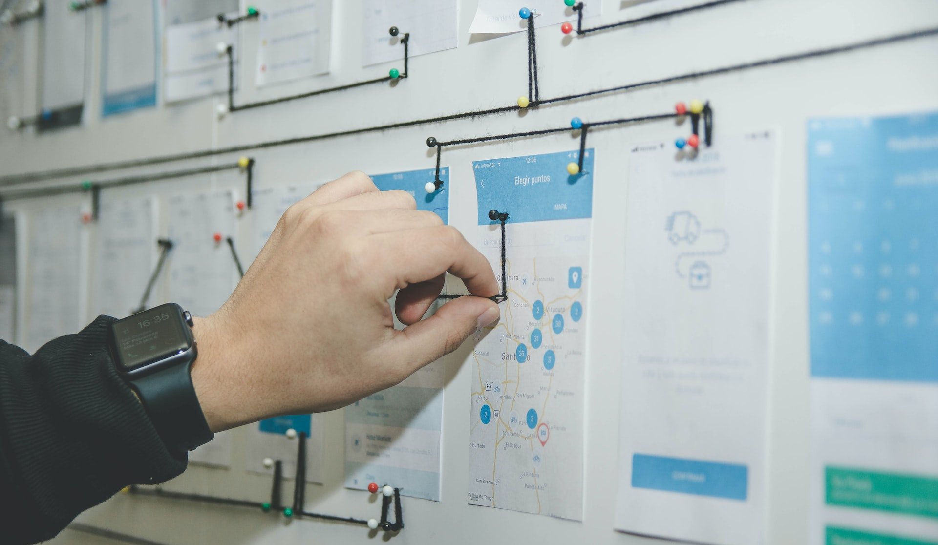 person working on blue and white paper on board